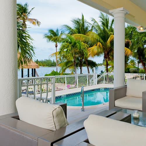 Villas exterior with pool and palm trees, facing the sea