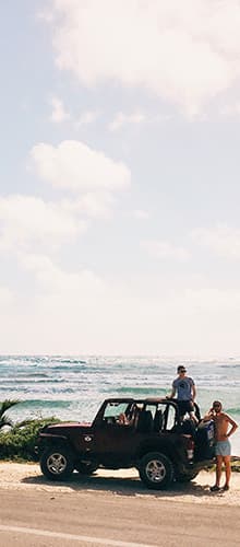 Man on a car in front of the ocean